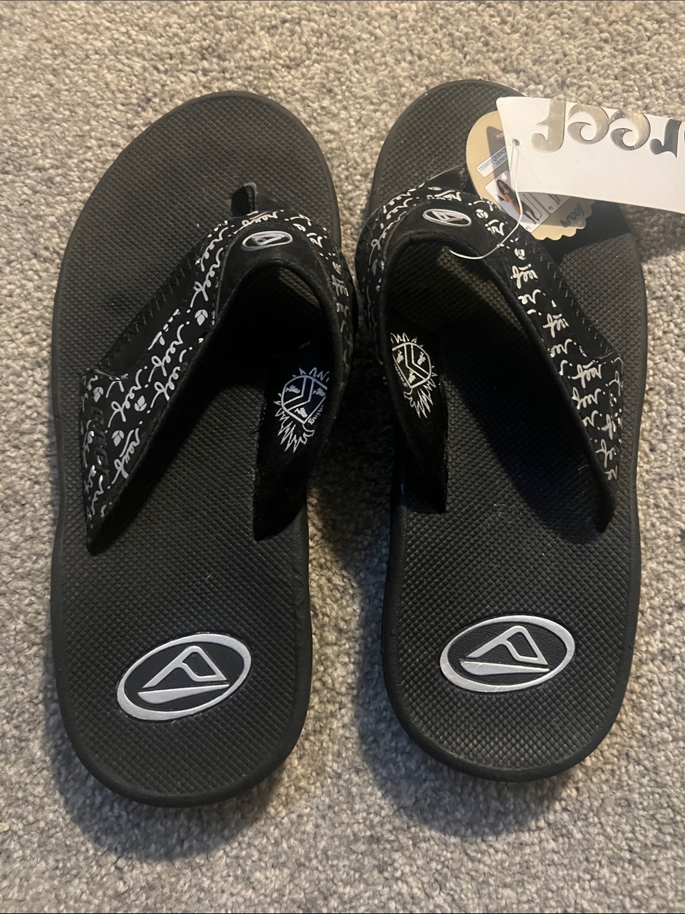 Reef Fanning women's  Black Flip Flops with White Script Detail